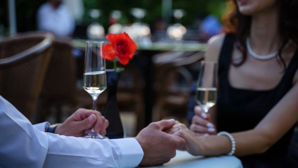 Couple frozen mid-awkward pause at a quiet dinner